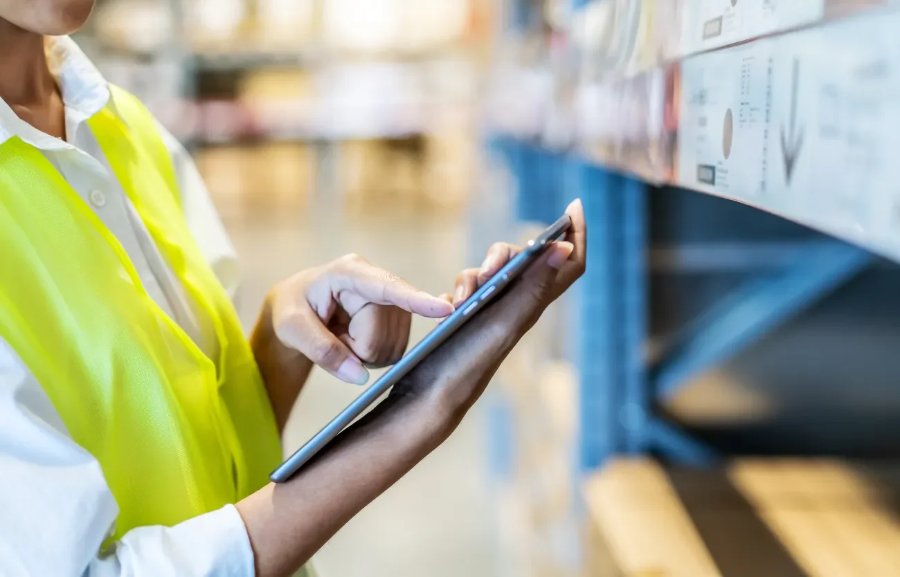 Kontrolle des Unternehmenslagers durch eine Mitarbeiterin mit Tablet