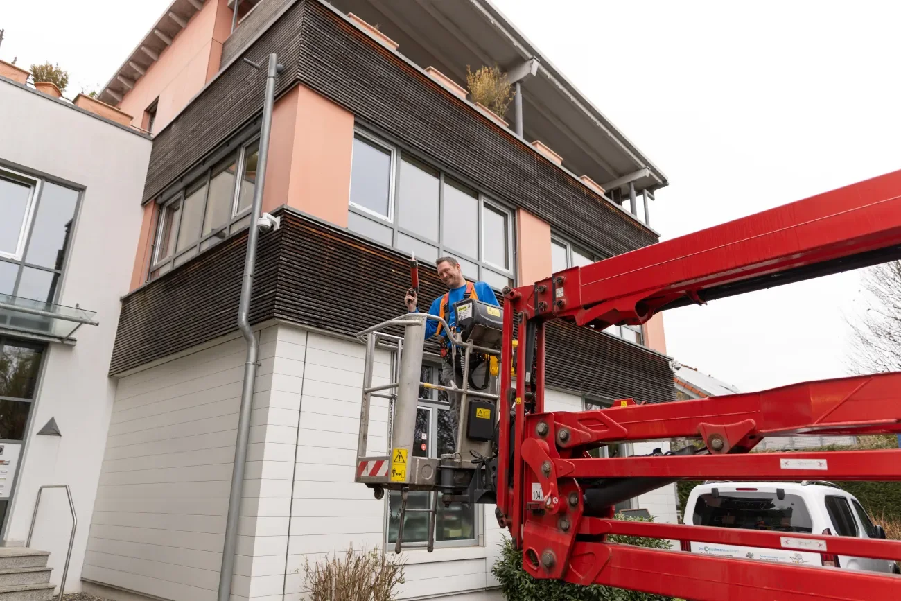 Schädlingsbekämpfer auf Hubwagen beim Taubenschutz