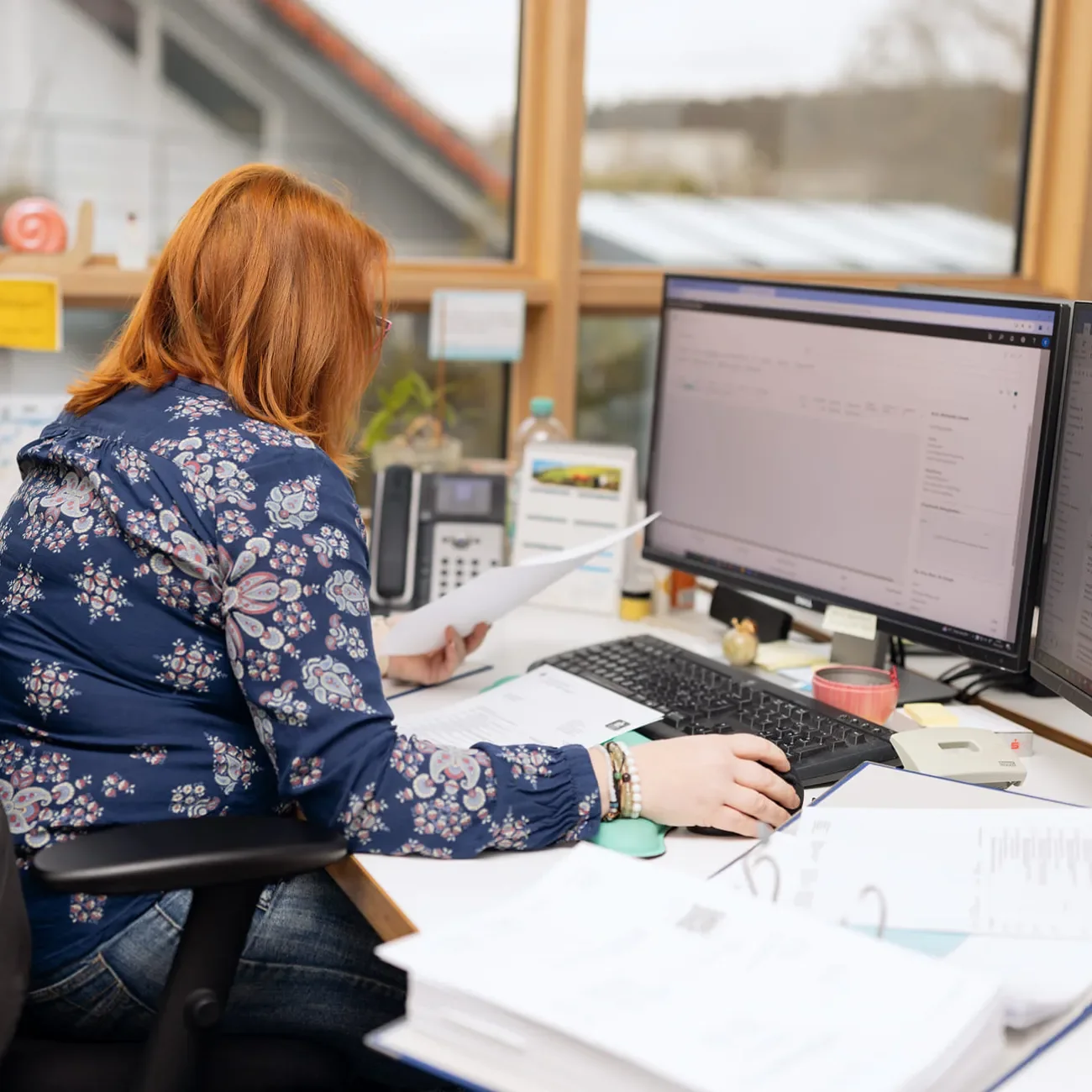 Mitarbeiterin in der Qualitätssicherung bereitet neue Aufträge am Computer vor
