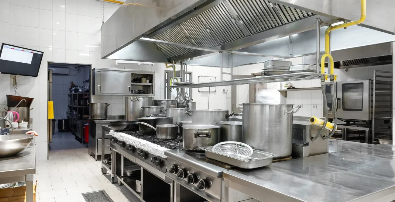 Aufgeräumte Industrieküche mit Töpfen auf dem Herd